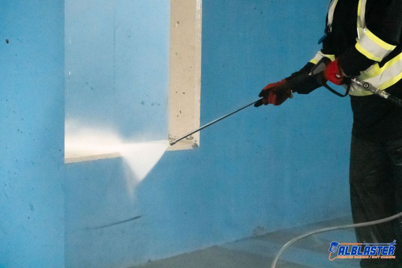 Technician is doing Easypark underground parking lot (wall) pressure washing.