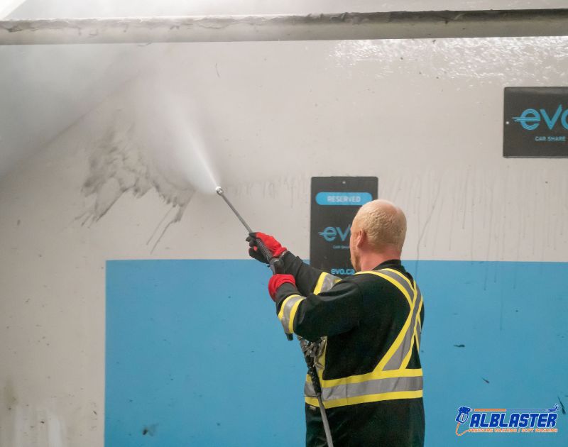 Technician is doing Easypark underground parking lot (wall) pressure washing.