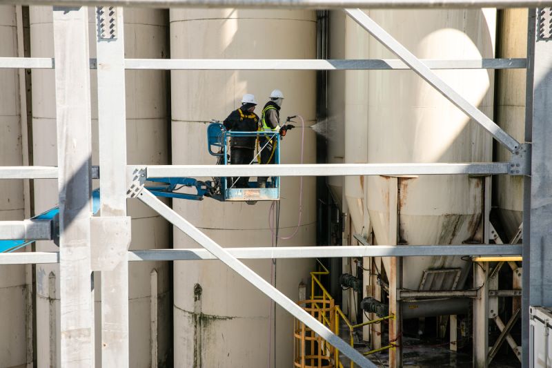 Technician is performing Industrial pressure washing silos service 7