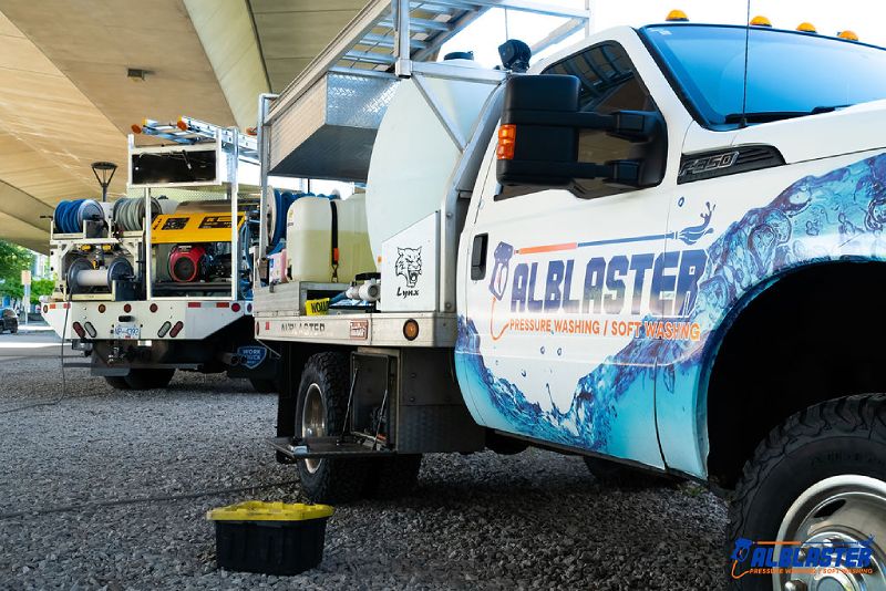 Alblaster trucks are parked under Cambie Bridge before starting the job.